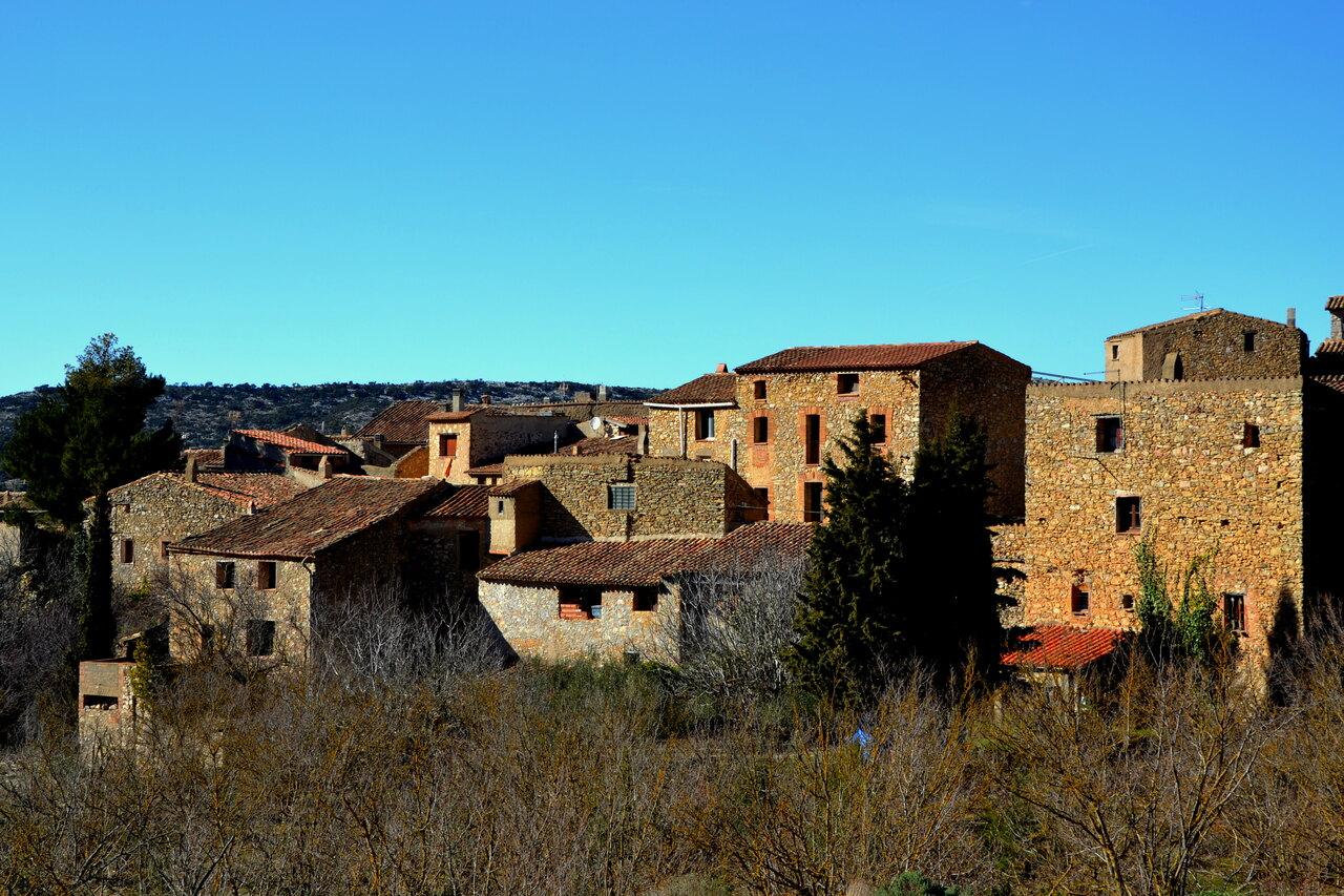 Tightly grouped stone houses and tiled roofs in the village of Llaberia